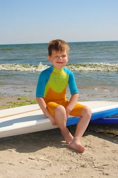 Novice surfer. The kid was sitting on a surfboard