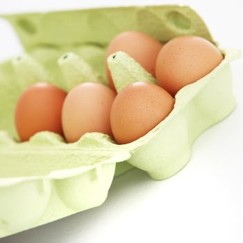 Fresh brown farm eggs in a cardboard carton ready to be cooked for breakfast or used as an ingredient in baking