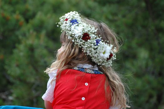 A little blond girl with a wreath in her hair on Midsummer´s Eve