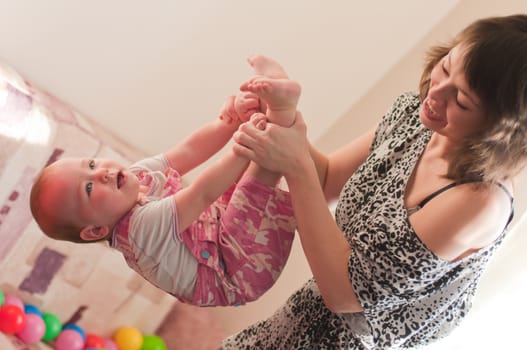 Smiling woman plays with little girl