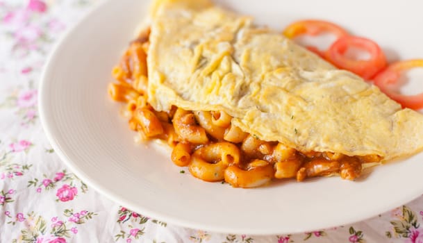 Fried macaroni with tomato sauce wrapped with omelette thai food