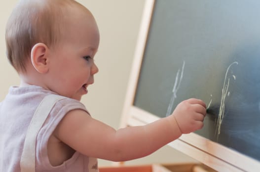 Little girl paints on the board