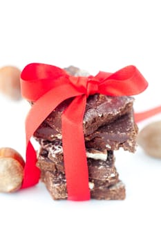 background of stack of chocolate with red ribbon and nuts