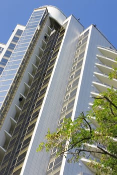 modern residential building with beautiful glass balconies on a background blue sky