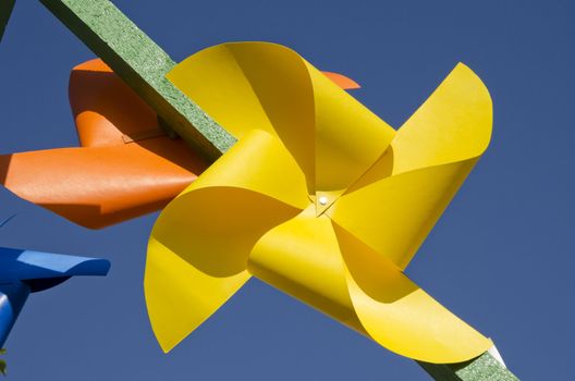 yellow paper windmill toy on blue sky background