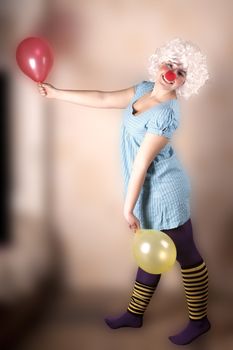 The girl - inflatable clown with balloons in hands on a blurred background