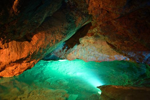 Illuminated underground river inside the cave