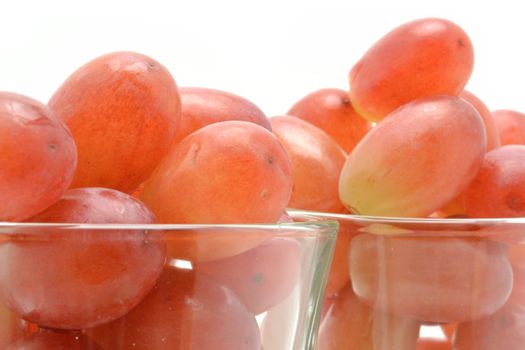 Red grapes in glasses over white background