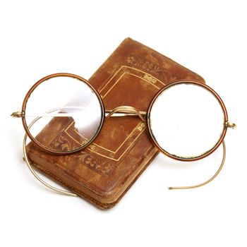 An isolated shot of an old 1800's book and spectacles.