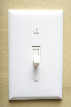 A closeup shot of a modern light switch on an interior wall.