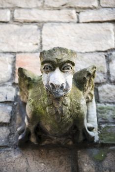 Close up shot of old church gargoyle covered in moss
