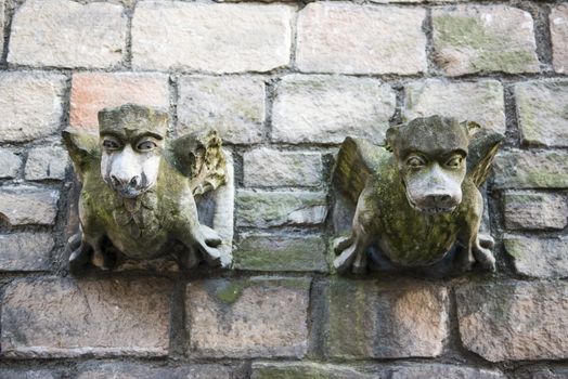 Two old church gargoyle covered in moss