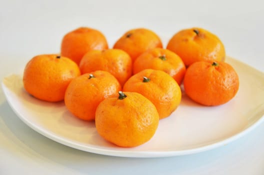 mini mandarin oranges on white dish 