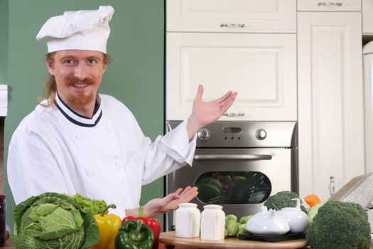 Young chef with vegetables, preparing lunch in kitchen