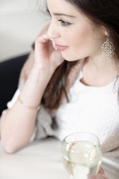 Attractive young woman enjoying a glass of wine on her sofa.