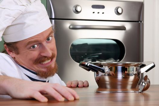 Funny young chef with a pot