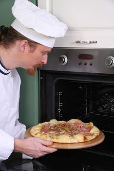 Young chef prepared italian pizza in kitchen