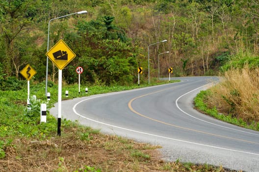 Country curves  road up the mountain and yellow sign