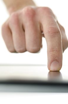 Front view of male hand working on touch screen device. Over white background.