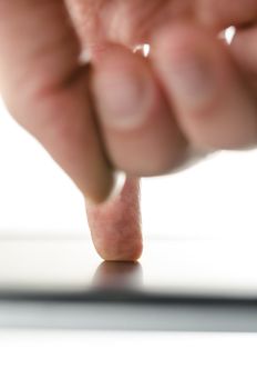 Rear view of male hand working on a modern touch pad. 