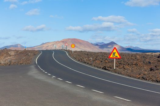 Empty road crossing the lava in the mountain, Lanzarote, Canary islands, Spain