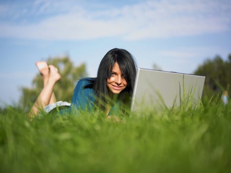 Young woman using laptop in park