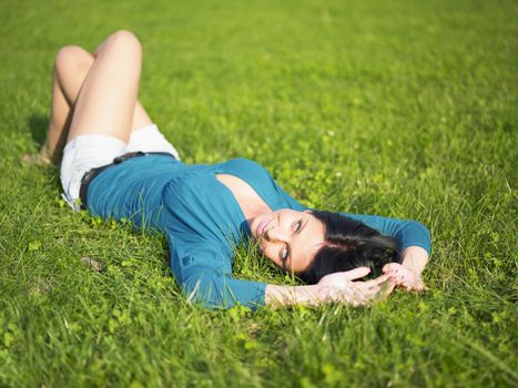 Young woman relaxing in park on green grass