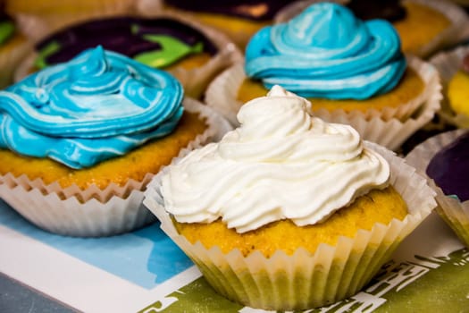 Some colored cupcakes with cream