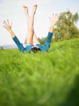 Young woman relaxing in park on green grass