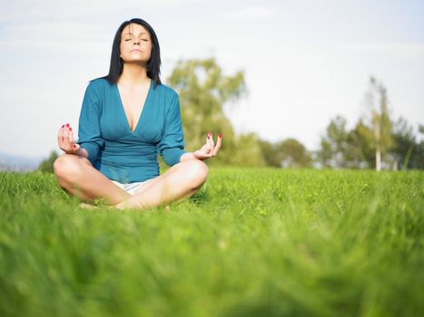 Young woman relaxing in park on green grass