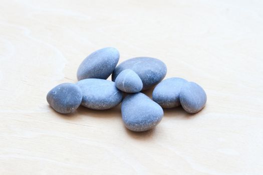 Smooth river rocks on a white wooden background