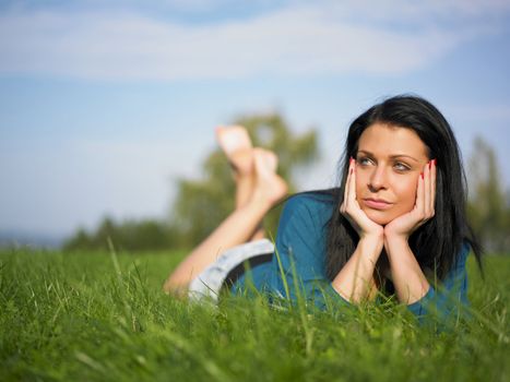 Young woman relaxing in park on green grass