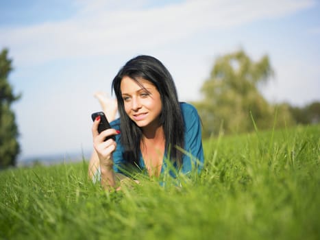 Young woman using mobile phone in park
