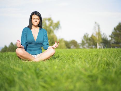 Young woman relaxing in park on green grass