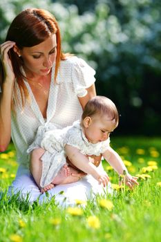 Happy mother and daughter on the green grass