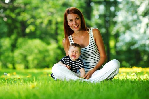 Happy mother and daughter on the green grass