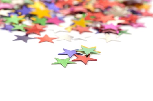 Christmas decoration of colored confetti stars against white background