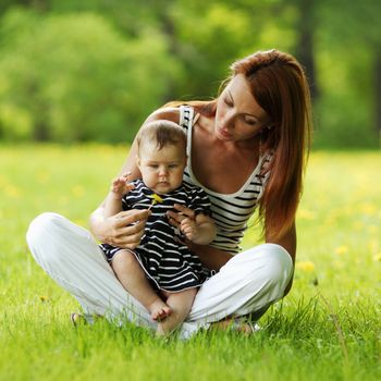 Happy mother and daughter on the green grass