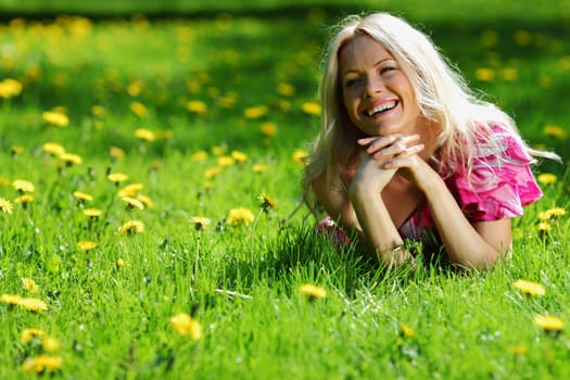  girl lying on the field of dandelions