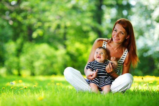 Happy mother and daughter on the green grass