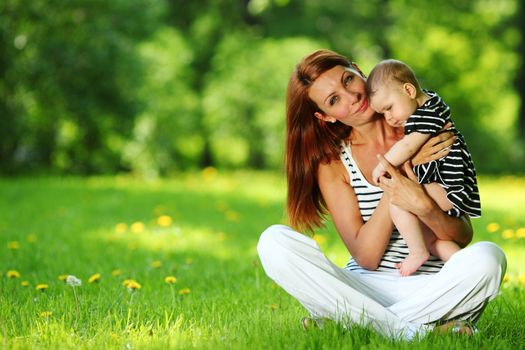 Happy mother and daughter on the green grass