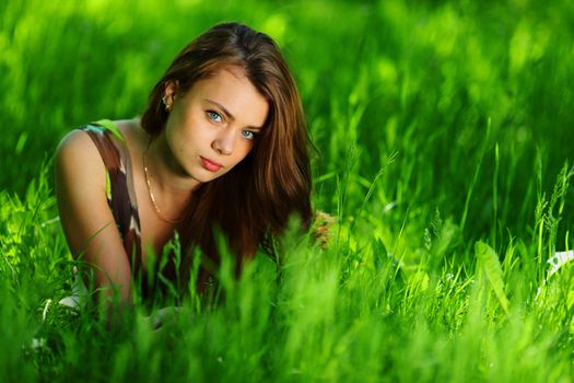 brunette lying on green grass