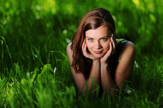 brunette lying on green grass