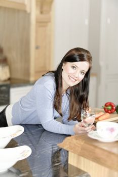 Beautiful young woman preparing the ingredients for a meal in her kitchen.