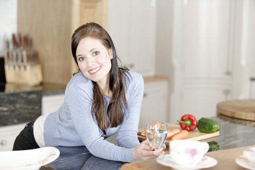 Beautiful young woman preparing the ingredients for a meal in her kitchen.