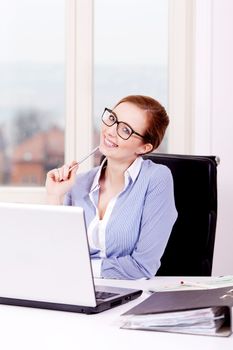 smiling successful young business woman in office at work