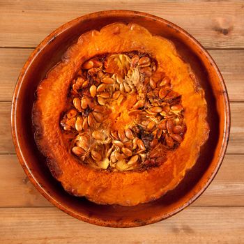 cutted half pumpkin roasted pumpkin on pottery clay dish