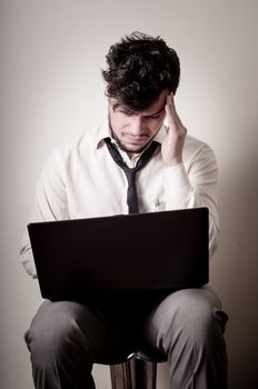 stressed businessman using notebook on gray background