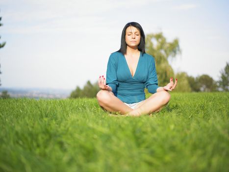 Young woman relaxing in park on green grass