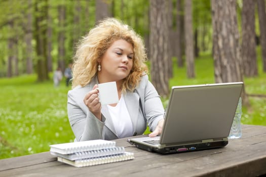 Young woman using laptop in park